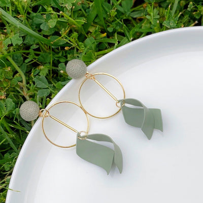 Green Ribbon Dangle Earrings on Grass Background